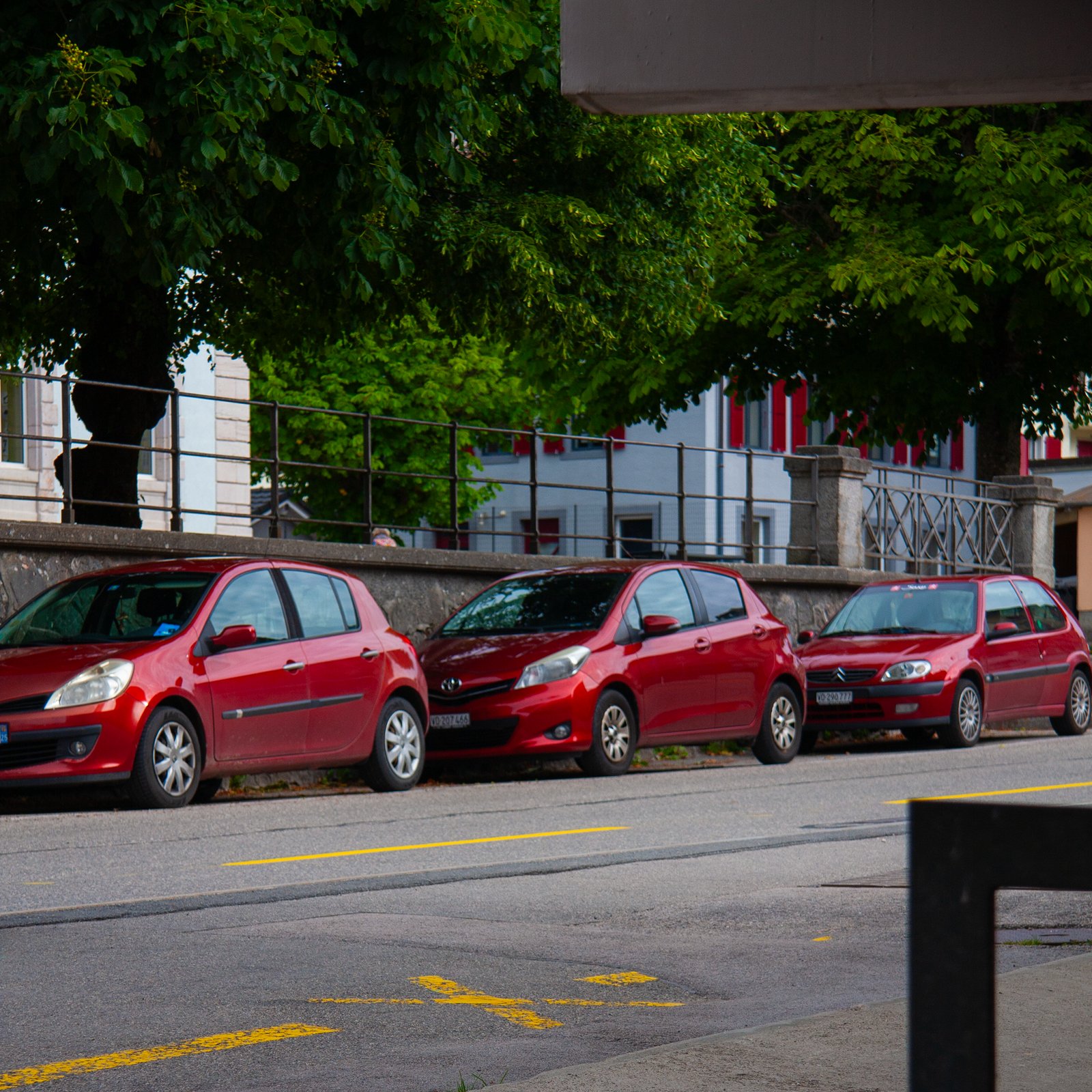 Trois voitures rouges garées